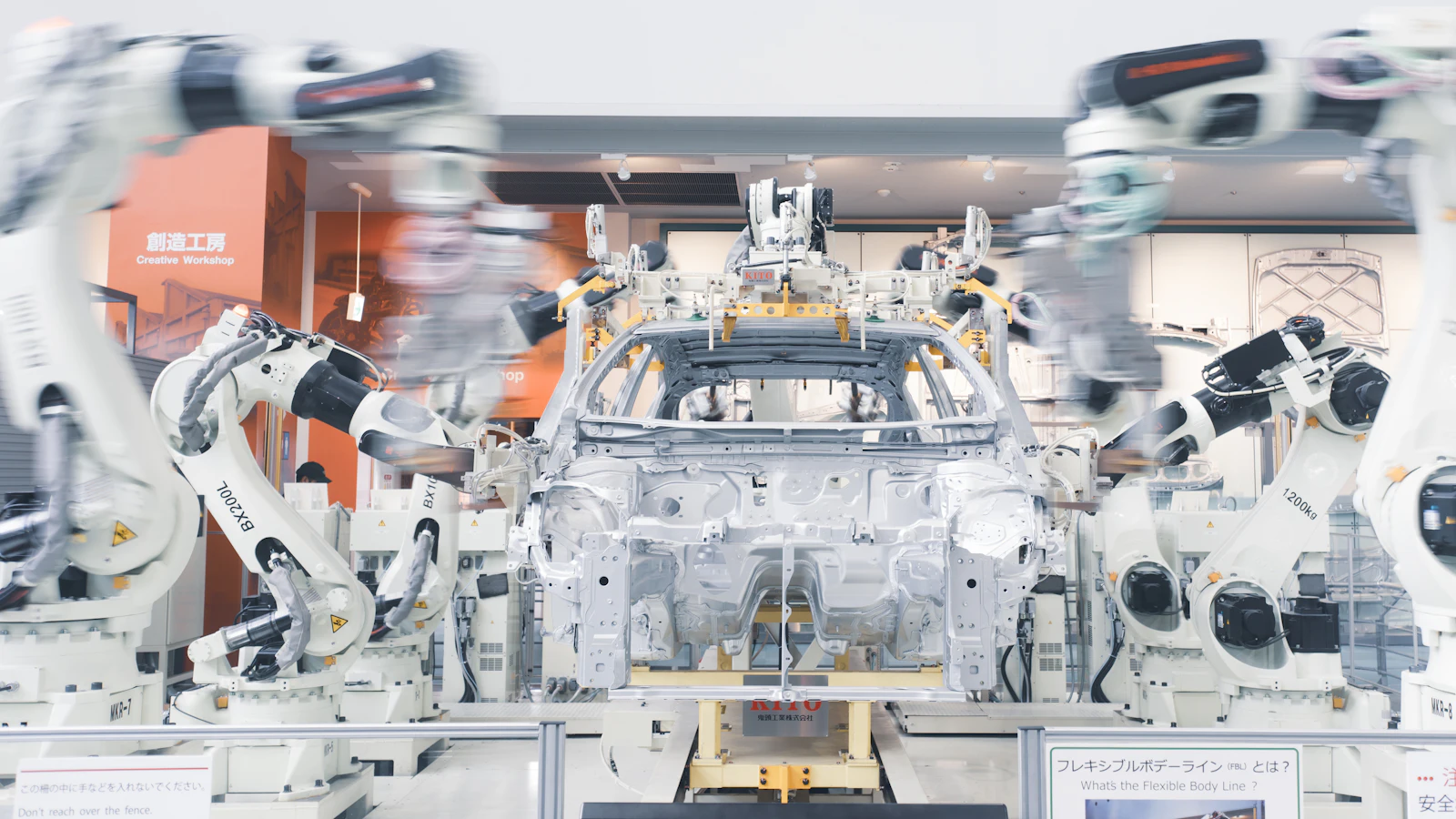 Braços robóticos montando o chassi de um carro em uma linha de produção