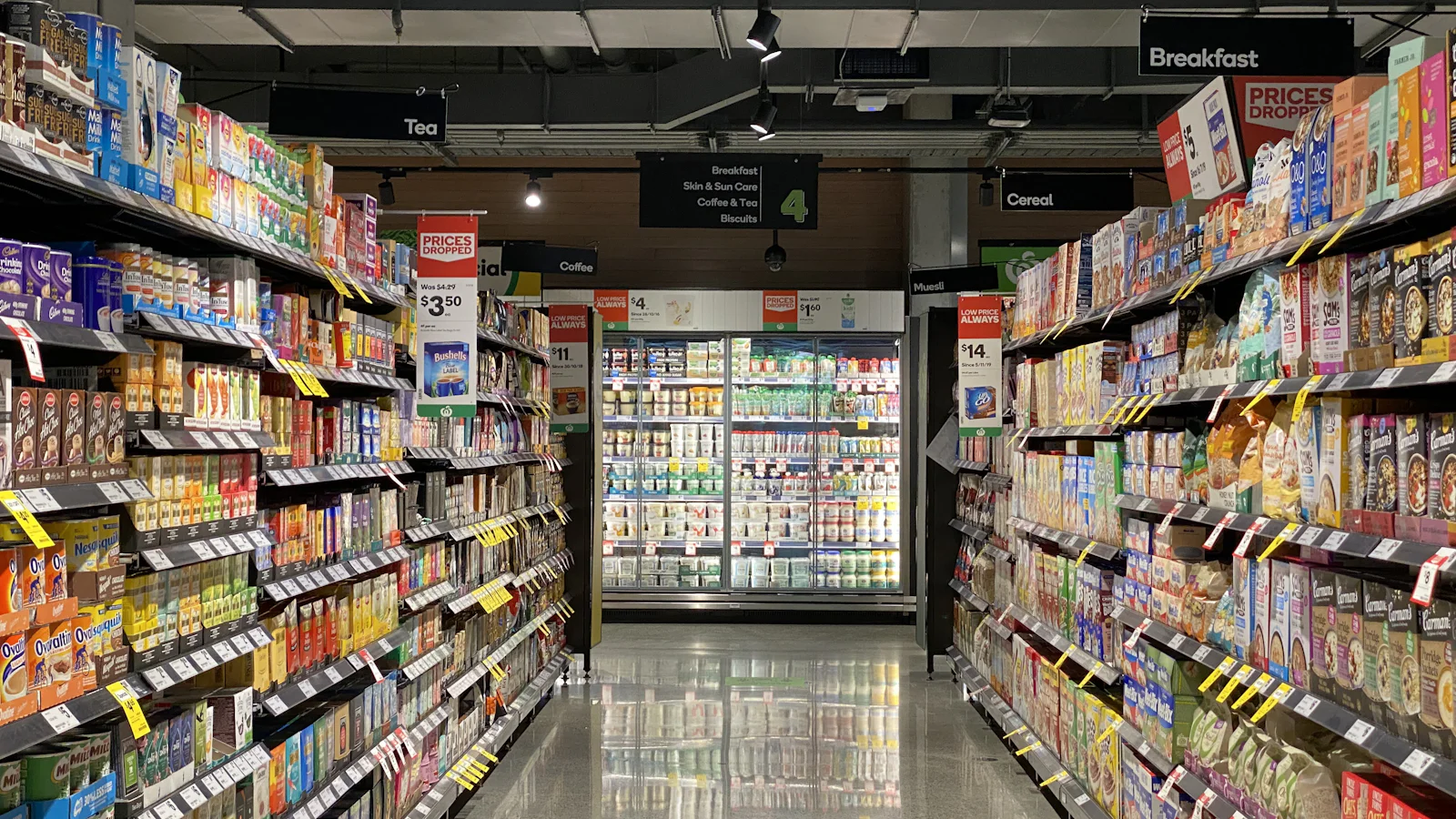 Corredor de supermercado com prateleiras abastecidas dos dois lados